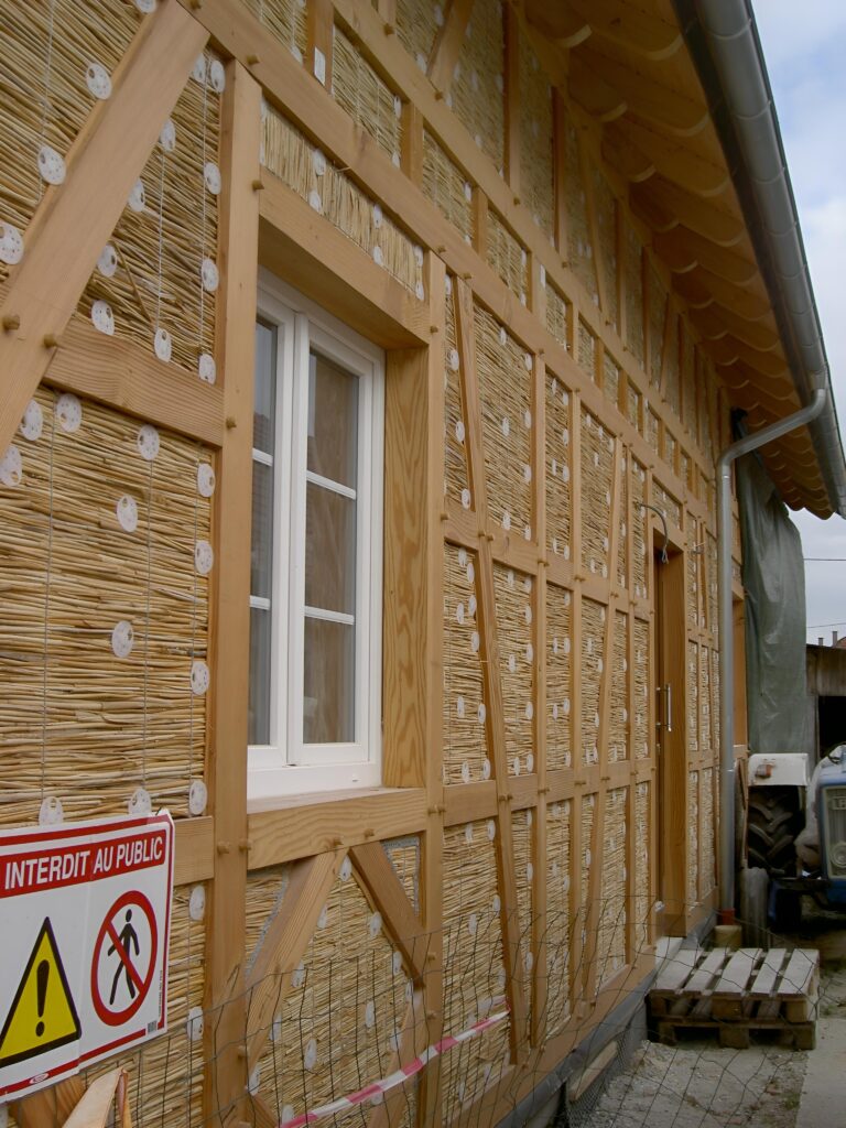 Terra Roseau : Réalisation extérieure d'une isolation naturelle perspirante et support d'enduit en panneau de roseau biosourcé.