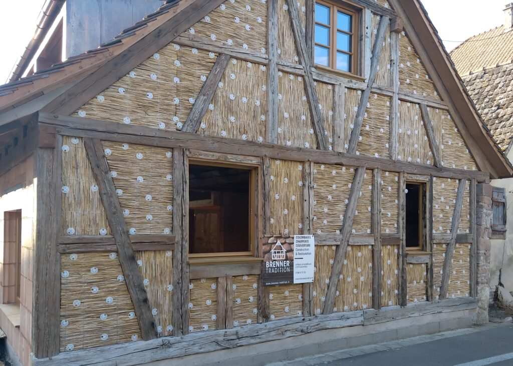 Rénovation écologique d'une maison avec isolation extérieure naturelle en panneaux de roseau support d'enduit avant finition.